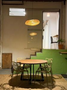 a table and chairs in a room with a green wall at Casinha Verde, Itacaré in Itacaré