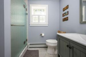 a bathroom with a toilet and a sink and a window at Colonels Quarters in Kennebunk +19 photos