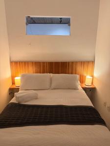 a bedroom with a large bed with two lamps at Casinha Verde, Itacaré in Itacaré