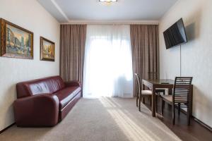 a living room with a couch and a table and a television at HARMONY Apart in Truskavets