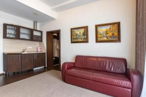 a living room with a red couch and a sink at HARMONY Apart in Truskavets