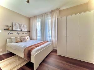 a bedroom with a bed and a large white cabinet at Pearly EuroPoint in Saint-Louis