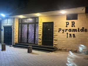 a brick building with a front door with the wordspr pyramids on it at Pr Pyramids Inn in Cairo