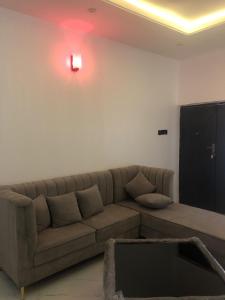 a living room with a brown couch and a red light at The 7th Haven in Uyo