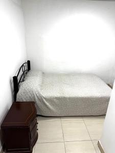 a small bedroom with a bed and a suitcase at Casa hotel Manhattan L&P in Choachí +7 photos