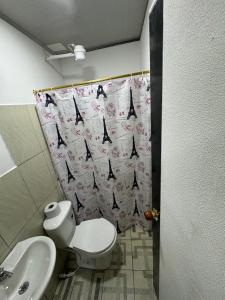 a bathroom with a toilet and a sink and a shower curtain at Casa hotel Manhattan L&P in Choachí