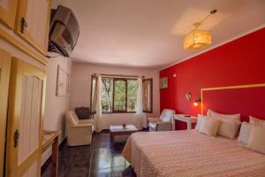 a hotel room with a bed and a red wall at Posada Shemak in Villa General Belgrano