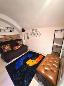 a living room with a couch and a bed at Tiny studio, rustic style, historic center in Sanremo