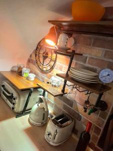 a kitchen with a brick wall with shelves and a toaster at Tiny studio, rustic style, historic center in Sanremo +41 photos