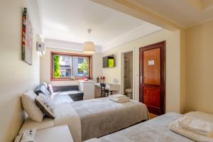 a bedroom with two beds and a living room at Maia Oporto Suites in Maia