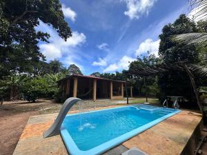a swimming pool in front of a house at Chalé Canto dos Pássaros in Viçosa do Ceará