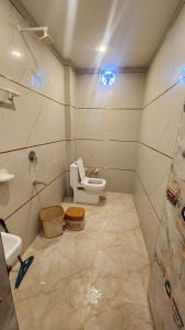 a bathroom with a toilet and a sink at BRAHMANCHAL guest house in Barsāna