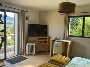a living room with a flat screen tv and a tv stand at Chambres d hôtes les Romarins in Cantaron