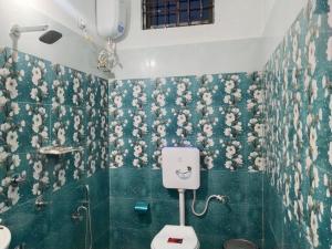 a bathroom with a toilet and flowers on the wall at Bhanu Homestay in Nowgong +60 photos