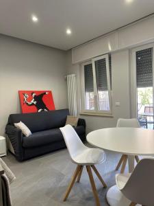 a living room with a black couch and a table at Casa di WR in Imperia