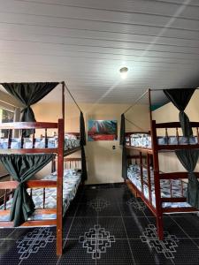 a room with three bunk beds on a boat at Hostel Caiçara in Santo Amaro
