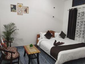 a bedroom with two beds and a table and a chair at Bhanu Homestay in Nowgong