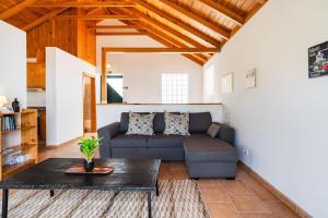 a living room with a couch and a table at GuestReady - Casa das Estrelas in Estreito da Calheta +33 photos