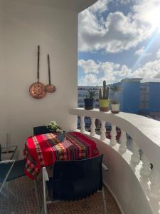 a table and chairs on a balcony with a view at Moderne appartement in Larache