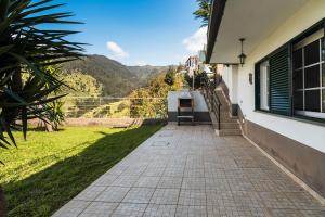 a walkway outside of a house with mountains in the background at GuestReady - Casa das Estrelas in Estreito da Calheta