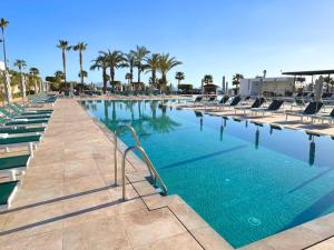 a large swimming pool with chairs and palm trees at The Place Palacio Mojacar & Spa by ALEGRIA Adults Only in Mojácar +76 photos