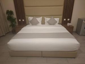 a bedroom with a large bed with white sheets and pillows at روز الخيال للشقق المخدومة 2 in Al Kharj