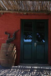 a door of a red building with a barrel in front at Finca Magdalena Casa de Campo in San Rafael