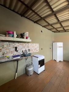 a kitchen with a counter and a refrigerator at Hostel Caiçara in Santo Amaro +13 photos