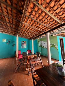 a dining room with a wooden table and chairs at Hostel Caiçara in Santo Amaro
