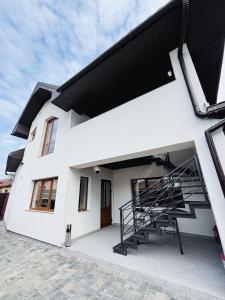 a white house with a black roof at Old Friend Guest House in Berehove