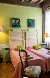 a room with two beds and a chair at B&B Amarantha Gothica Genoa in Genoa