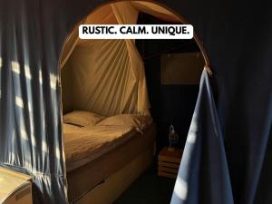 a bed with a sign that readsrusticcalemiaemia university at Nomads Village in Bled