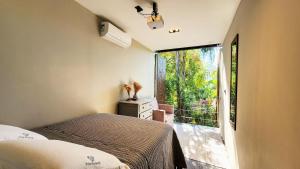 a bedroom with a bed and a large window at SPA BOA VISTA - Refugio in Itatiba