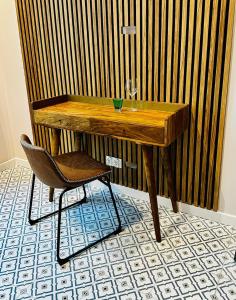 a wooden table with a chair and a wine glass at Refugium Lodziense II - Quiet luxury in the center of Lodz in Łódź