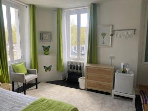 a bedroom with green curtains and a bed and a chair at Les Papillons in Verteillac +34 photos