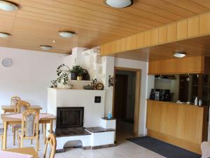 a living room with a fireplace and a wooden ceiling at Hotel Garni Silberdistel in Nenningen