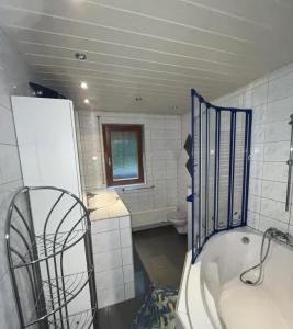 a bathroom with a tub and a sink and a toilet at Hotel Garni Silberdistel in Nenningen +22 photos