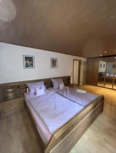 a bedroom with a large bed with white sheets and pillows at Hotel Garni Silberdistel in Nenningen
