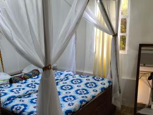 a bedroom with a bed with a canopy and a window at Mizpah House in Kikuyu +10 photos