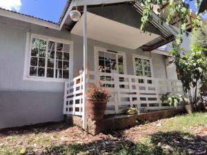 a house with a white fence and a potted plant at Mizpah House in Kikuyu