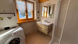 a bathroom with a washing machine and a sink at Bilocale baciato dal sole in Andalo +13 photos
