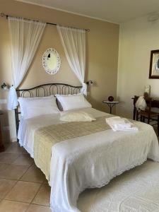 a bedroom with a large bed with white sheets at Agriturismo Valle Martina in Saturnia