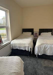 a bedroom with two beds and a window at Town Centre House Sleeps 8 with parking in Stafford