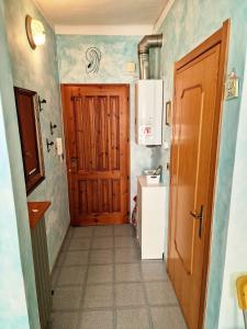a small kitchen with a wooden door and a refrigerator at Bell-House in Varazze