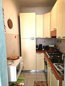 a kitchen with white cabinets and a refrigerator at Bell-House in Varazze