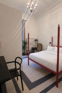 a bedroom with a bed and a chair and a chandelier at Dimora di Duen - Villa Storica di Charme in Villa San Giovanni