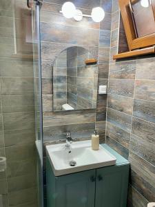 a bathroom with a sink and a mirror at Green Mountain Resort in Scrind-Frăsinet +58 photos