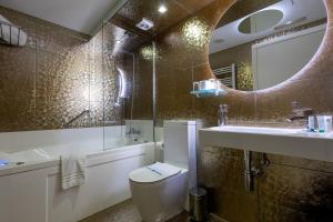 a bathroom with a toilet and a sink and a mirror at Casas Reais Boutique in Santiago de Compostela +111 photos