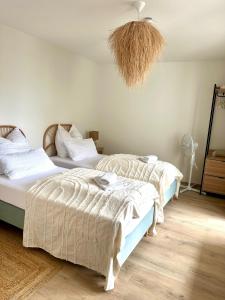 two beds in a bedroom with a chandelier at Stilvolle 3-Zimmer-Wohnung für business und family bis 6 Personen in Sindelfingen