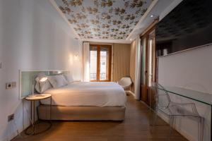 a bedroom with a bed with a floral patterned ceiling at Casas Reais Boutique in Santiago de Compostela